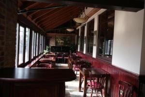 a dining room with tables and chairs and windows at The Plough Inn in Pocklington