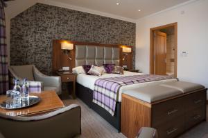 a hotel room with a bed and a chair and a table at Cruachan Hotel in Fort William