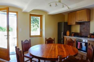 cocina con mesa de madera y cocina con nevera en Chez la Nonna, en Saint-Jean-le-Centenier 16 fotos más