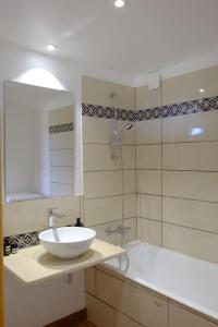 y baño con lavabo blanco y bañera. en Chez la Nonna, en Saint-Jean-le-Centenier