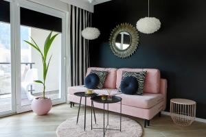 sala de estar con sofá rosa y espejo en Apartament Sun House z prywatną SAUNĄ KOMINKIEM i widokiem na SKRZYCZNE en Szczyrk