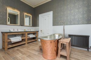 een badkamer met een koperen bad en 2 wastafels bij The Lake House, Wansfell Holme, Windermere in Ambleside