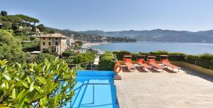 a pool with chairs and a view of the water at Regina Elena Dependance in Santa Margherita Ligure