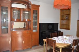 una sala da pranzo con tavolo, TV e armadio di Mebo House a Kutaisi