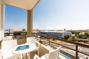 balcón con mesa, sillas y vistas en Eltina Hotel en Rethymno