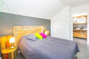 a bedroom with a bed with two colorful pillows at Lagoon ! Jolie villa à 2 pas du lagon de la Saline in La Saline les Bains