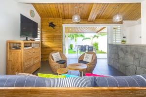 una camera con letto, sedie e televisore di Lagoon ! Jolie villa à 2 pas du lagon de la Saline a La Saline Le Bains
