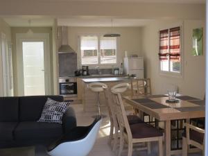 eine Küche und ein Wohnzimmer mit einem Tisch und einem Sofa in der Unterkunft gite horizon in Neulise
