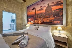 a bedroom with a large painting above a bed at Laparelli Suites: Luxury Suite 2 in Valletta