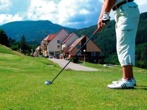 une personne joue au golf sur un terrain dans l'établissement Goélia Le Domaine du Golf, à Ammerschwihr
