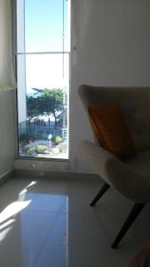 een stoel in een kamer met een raam bij Lindo Apartamento em Balneário Camboriú in Balneário Camboriú