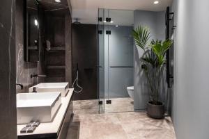 a bathroom with two sinks and a shower and a toilet at Perianth Hotel in Athens