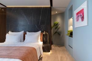 a bedroom with a large bed with a black headboard at Perianth Hotel in Athens