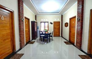 un corridoio con tavolo e sedie in una casa di nDalem Eyang Dwijo a Yogyakarta