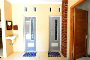 un bagno con due porte e un lavandino di nDalem Eyang Dwijo a Yogyakarta