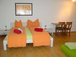 a bedroom with two beds with orange pillows at Gasthof Raben in Eschenz