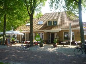 un bâtiment avec des tables et des vélos garés devant lui dans l'établissement Hotelsuites Ambrosijn, à Schiermonnikoog
