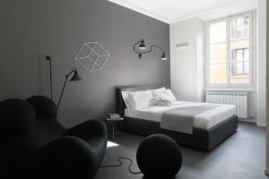 een slaapkamer met een bed, een stoel en een raam bij Brera Apartments in Moscova in Milaan