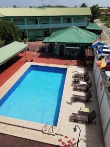 einen Blick über einen Pool mit Stühlen und ein Gebäude in der Unterkunft De Kolibrie Appartementen in Paramaribo