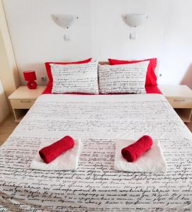 a bed with red and white pillows on it at Central Studios & Rooms in Ohrid