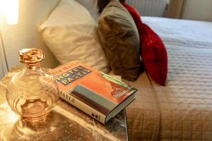 - une table en verre avec un livre et une bouteille sur un lit dans l'établissement Hotel Pastis, à Maastricht