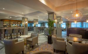 a hotel lobby with a bar and tables and chairs at Maldron Hotel, Newlands Cross in Clondalkin 