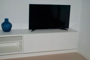 a flat screen tv sitting on top of a white cabinet at Ventum Suite in Tarifa