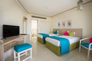 a hotel room with two beds and a flat screen tv at Shams Lodge in Hurghada