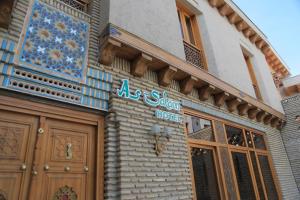 a store with a sign on the side of a building at As-Salam Boutique Hotel in Bukhara