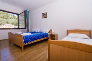 a bedroom with two beds and a window at Apartments Jozic in Seget Vranjica