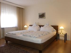 ein Schlafzimmer mit einem Bett mit Kissen und einem Fenster in der Unterkunft Weingut & Gästehaus Edwin Hoffmann in Trittenheim