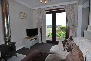 a living room with a couch and a television at 11 Laigh Isle in Isle of Whithorn