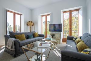 a living room with two couches and a tv at Ohliving Santa Cruz in Seville