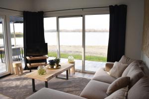 a living room with a couch and a tv and a table at Strandparc Nulde in Putten