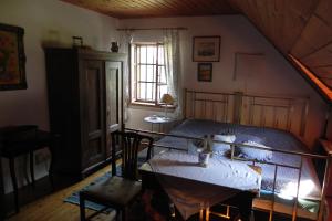 een slaapkamer met een bed, een tafel en een raam bij Ferienhaus Himmelreichmühle in Rettenberg