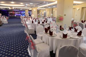 a banquet hall with white tables and white chairs at All Seasons Hotel Al Ain - Previously City Seasons in Al Ain +37 photos