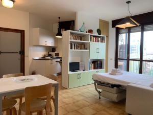a kitchen and a living room with a table and chairs at Kibilù - Via Cimabue in Milan