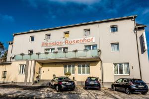 un edificio con dos coches estacionados frente a él en Pension Rosenhof, en Linz