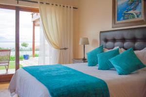 a bedroom with a large bed with blue pillows at Aquamarine Guest House in Mossel Bay +51 photos