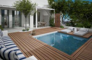 een achtertuin met een zwembad en een houten terras bij Kedros Villas in Agios Prokopios