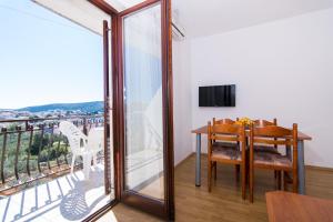 a dining room with a table and a balcony at Apartments Jozic in Seget Vranjica