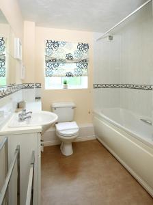 a bathroom with a toilet and a sink and a tub at Orchard Gate Apartments from Your Stay Bristol in Bristol