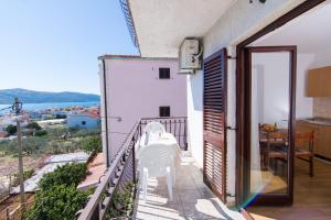 a balcony of a house with a table and chairs at Apartments Jozic in Seget Vranjica