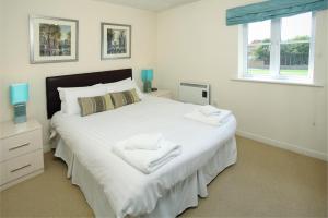a bedroom with a large white bed with towels on it at Orchard Gate Apartments from Your Stay Bristol in Bristol
