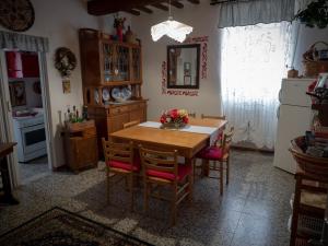 a kitchen with a table and chairs and a refrigerator at Casa Di Mamma Casa Vacanze in Genga