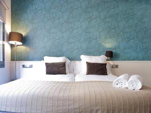 ein Schlafzimmer mit 2 Betten und einer blauen Wand in der Unterkunft Barcelona Fifteen central Aparthotel in Barcelona