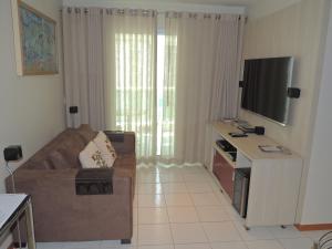 a living room with a couch and a flat screen tv at Apartamento 2 quartos Living Park Sul in Brasília