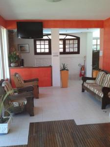 un soggiorno con divani e TV a schermo piatto di Maison Aires Malcher a Maricá