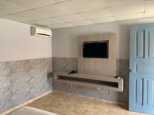 Habitación con TV de pantalla plana en la pared en RESIDENCIAL AGUADULCE, en Aguadulce