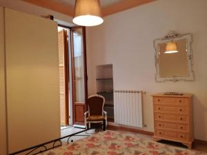 een slaapkamer met een bed, een dressoir en een spiegel bij a casa di renata in Monterosso al Mare